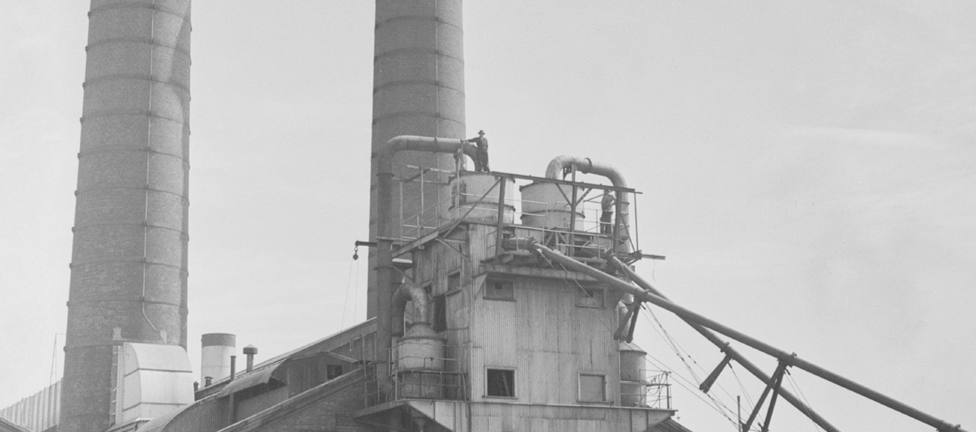 Black and white photo of old historic power station stacks from outside.